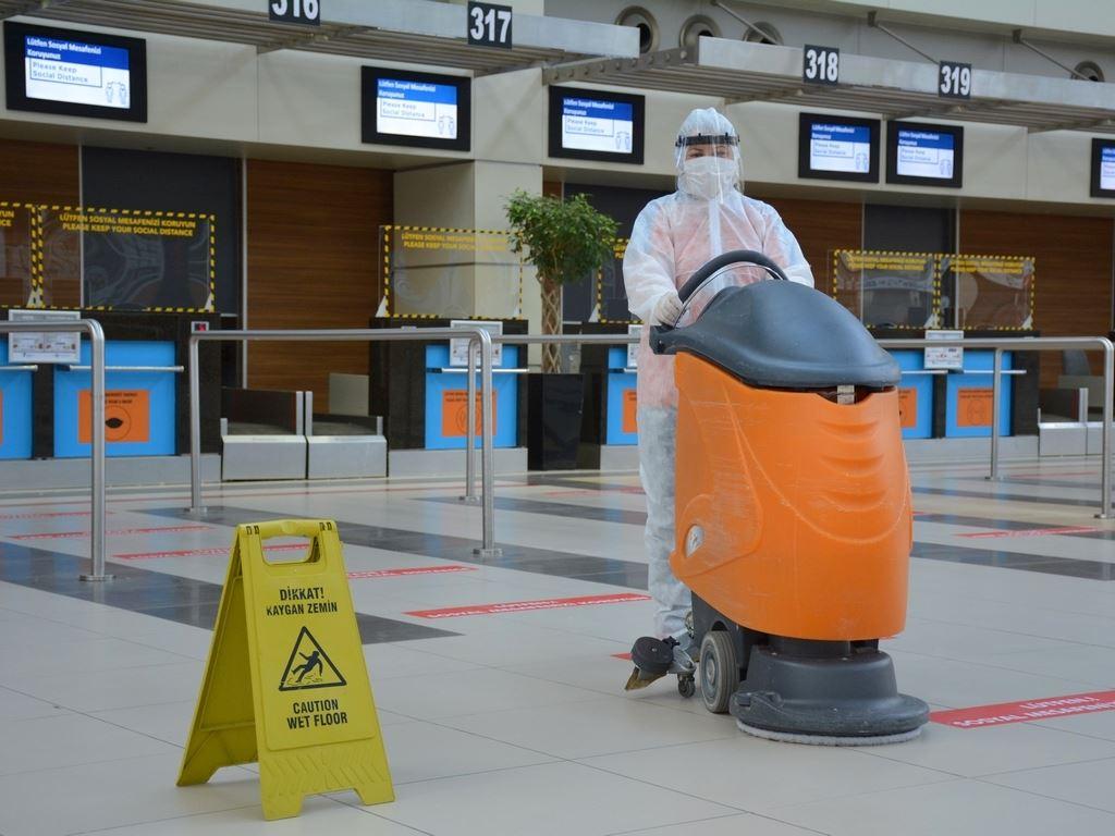 Arbeiter in Schutzkleidung reinigt Flughafen