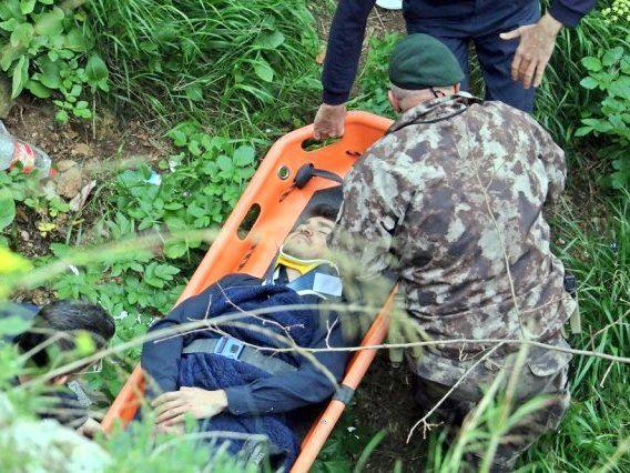 Mann in Militäruniform versorgt Verletzten auf Trage