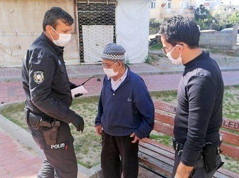 Zwei Polizisten mit Mundschutz kontrollieren älteren Mann