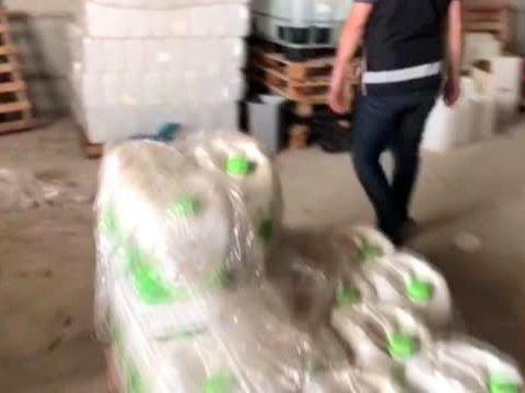 Türkischer Polizist steht neben Kanistern mit Schnaps