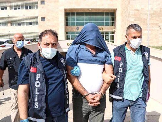 Zwei türkische Polizisten führen Mann in Handschellen ab