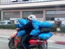 Mopedfahrer befördert acht blaue Säcke