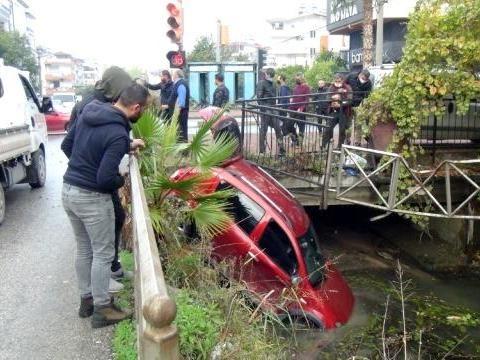 Rotes Auto steht schräg in einem Wasserkanal